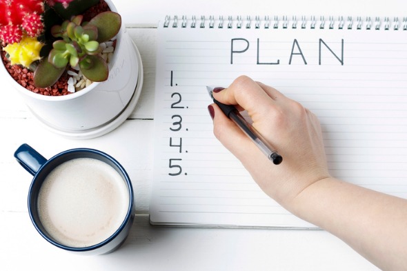 person writing up stepped plan on tablet